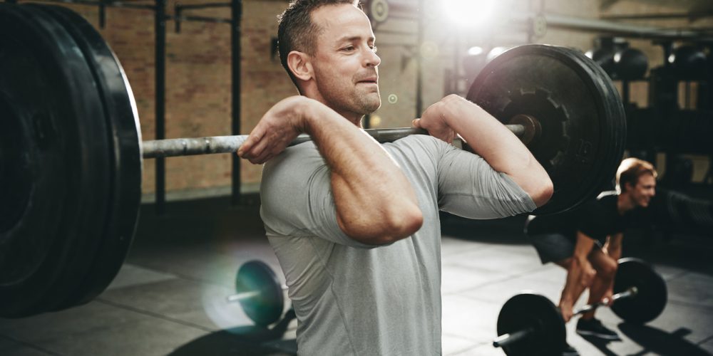 Man focused on lifting weights during a strength training session at the gym