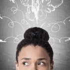 making better business decisions - Close up of a woman's face with rockets flying drawn on a blackboard in the background