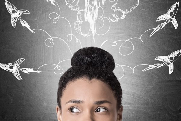 making better business decisions - Close up of a woman's face with rockets flying drawn on a blackboard in the background